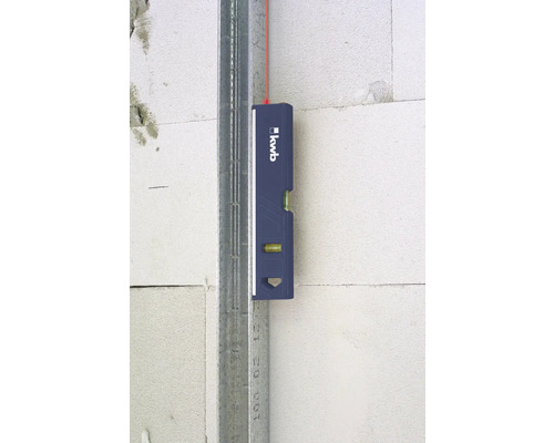 Kleine Wasserwaage an Metallprofil und Wand