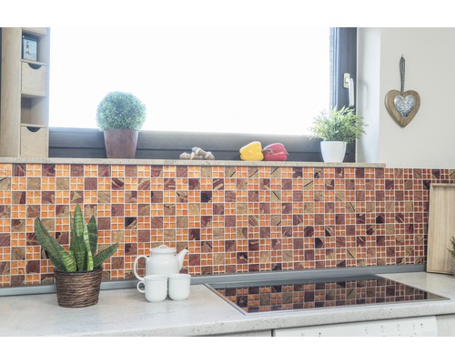 Küchenszene mit Mosaikfliesenwand, Pflanzen und Küchenutensilien auf der Arbeitsplatte.