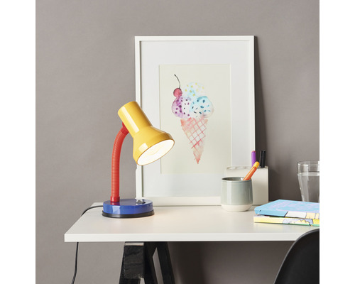 Schreibtisch mit farbenfroher Lampe, Bild und Büromaterialien