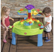 Kinder spielen mit einem interaktiven Wasserspieltisch im Freien.