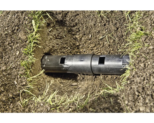 Drainagerohr im Erdreich mit Gras