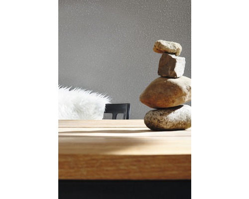 Dekorativer Steinturm auf einem Holztisch vor einer Tapete