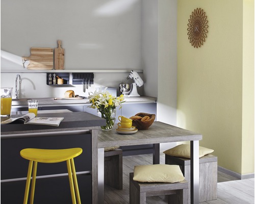 Helle Küche mit Esstisch, Stühlen und Küchengeräten.