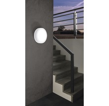 Eine runde Wandleuchte neben einer Treppe in einem Haus.