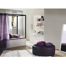Helles Zimmer mit Himmelbett, weißem Teppich, Sitzhocker, Kommode und Wandtapete mit Sternenmuster