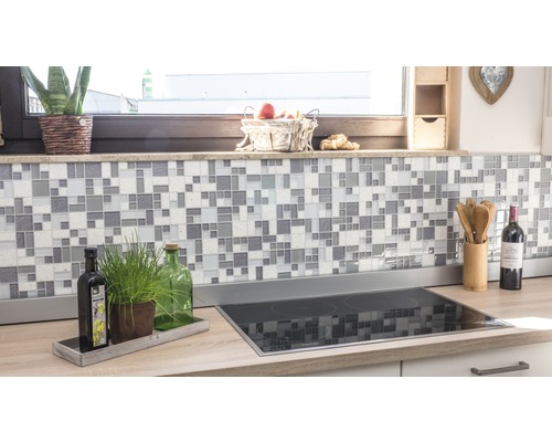 Küchenszene mit Mosaikfliesen an der Wand und Kochfeld auf der Arbeitsplatte.