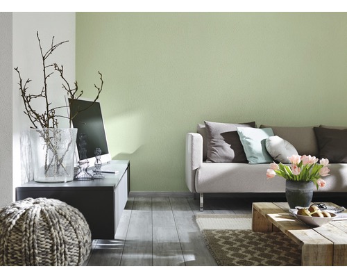 Wohnzimmer mit Sofa, Tisch, Dekoration und grün gestrichener Wand