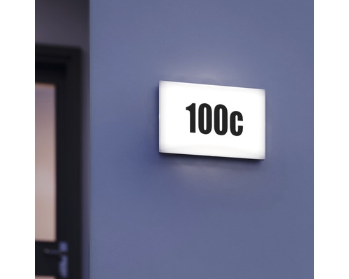 Beleuchtetes Türschild mit der Nummer 100c an einer Wand