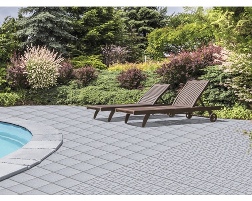 Garten mit zwei Liegestühlen und grauen Terrassenplatten