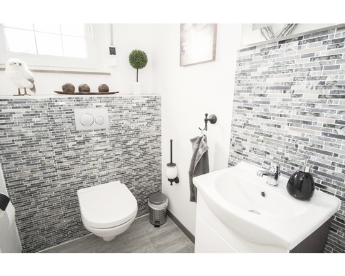 Helles Badezimmer mit Toilette, Waschbecken und Mosaikfliesen
