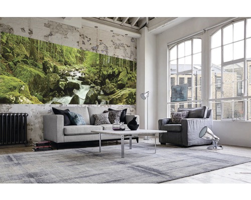 Wohnzimmer mit Sofa, Sessel, Tisch, Teppich und Fototapete mit Waldmotiv