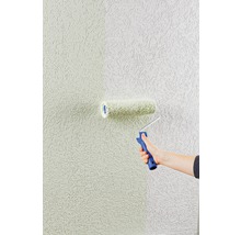 Eine Person streicht eine Wand mit einer Strukturrolle.