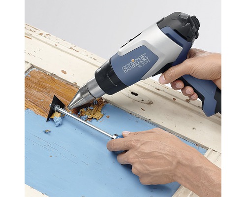 Heißluftpistole beim Entfernen von Farbe von einem Holzrahmen