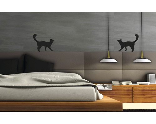 Schlafzimmer mit Bett, Lampen und Wandtattoos mit Katzenmotiven