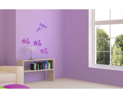 Wohnzimmer mit Wandtattoo, Bücherregal und Fenster.