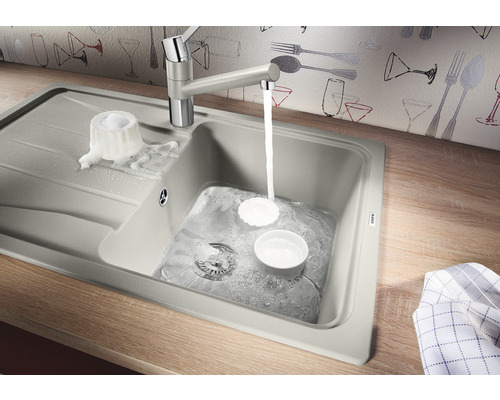 Spüle mit Abtropffläche, Wasserhahn und Spülbecken mit Wasser und Geschirr