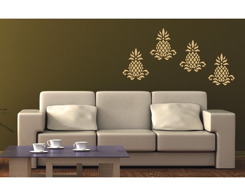 Wohnzimmer mit Sofa und dekorativen Wandtattoos mit Ananas-Motiv