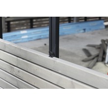Detailansicht eines Zauns mit Holzpaneelen und Metallpfosten zur Gartengestaltung.