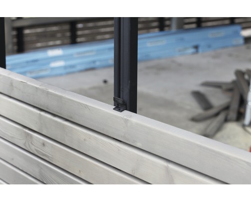 Detailansicht eines Zauns mit Holzpaneelen und Metallpfosten zur Gartengestaltung.
