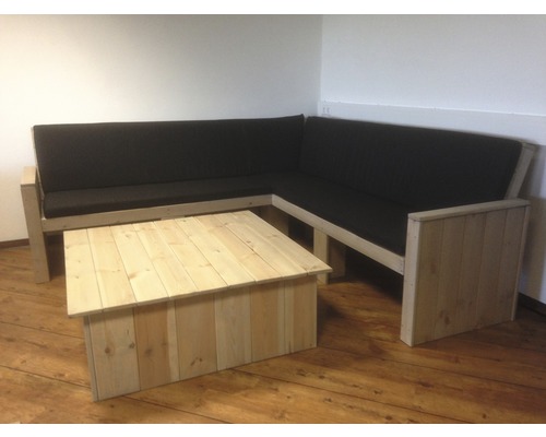 Ecksofa aus Holz mit Tisch und dunklen Kissen