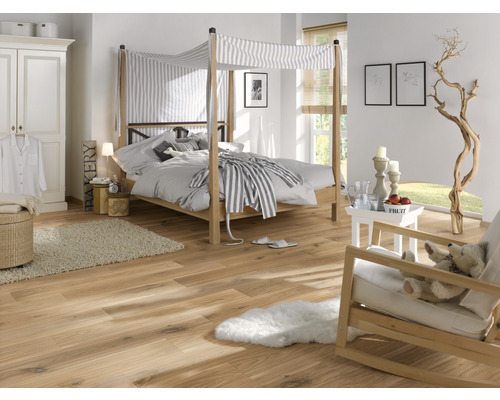 Schlafzimmer mit Himmelbett, Holzboden und heller Einrichtung für eine freundliche Atmosphäre.