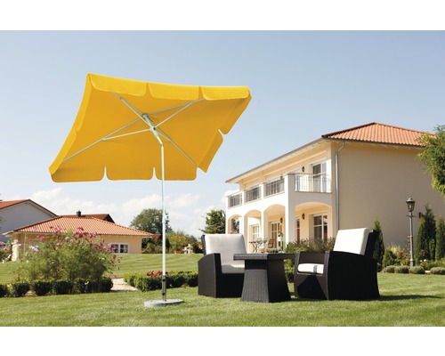 Gelber Gartenschirm mit Gartensitzgruppe auf Rasen vor Wohnhaus