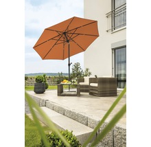 Szene mit Sonnenschirm, Gartenmöbeln und dekorativen Elementen auf einer Terrasse