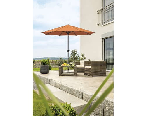 Terrasse mit Gartenschirm, Gartenmöbeln und Steinstufen vor einem Haus