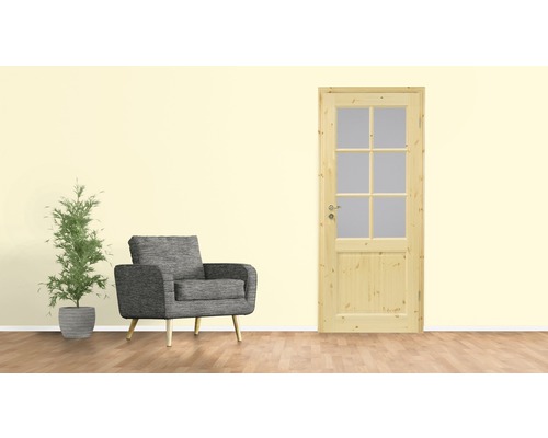 Wohnzimmer mit Holztür, Sessel und Pflanze