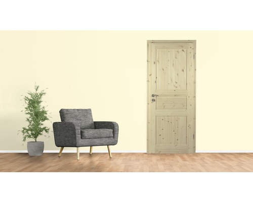 Zimmertür aus Holz mit Drückergarnitur in einem hellen Raum mit Sessel und Pflanze
