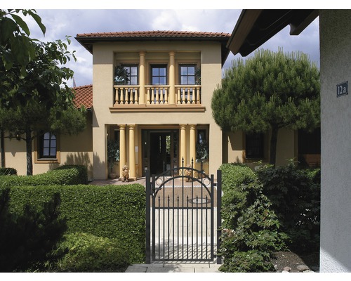 Hausfassade mit Säulen, Balkon und schmiedeeisernem Tor