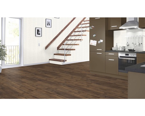 Innenraum mit braunem Laminatboden, Treppe, Küche und Balkontür.