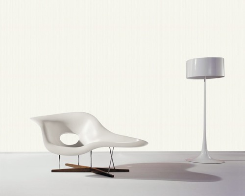 Innenraumszene mit Lounge-Sessel aus Kunststoff, Metall und Holz sowie Stehleuchte