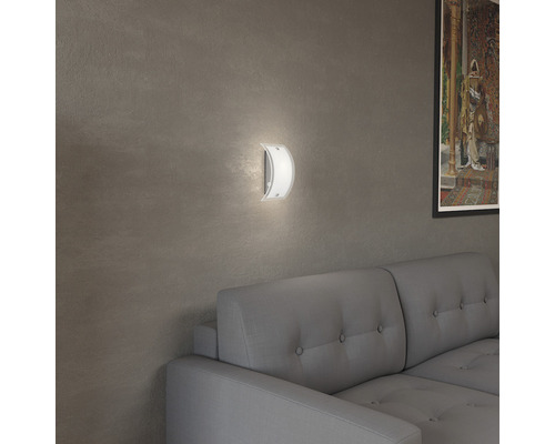 Wandleuchte aus Glas und Metall in einem Wohnzimmer