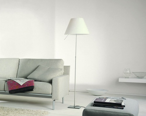 Wohnzimmer mit Sofa, Stehlampe und Bücherstapel