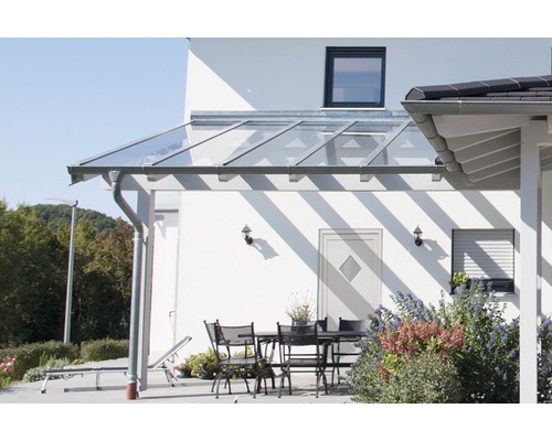 Terrasse mit Glasüberdachung und Gartenmöbeln an einem sonnigen Tag