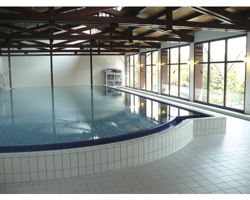 Schwimmbad mit Fliesenboden und großem Fenster