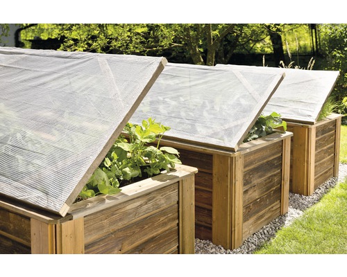 Drei Hochbeete mit transparenten Abdeckungen im Garten.