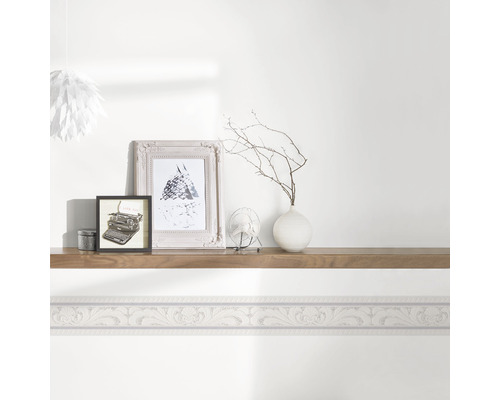 Wohnraum mit Bordüre und Dekoration auf einem Wandregal.