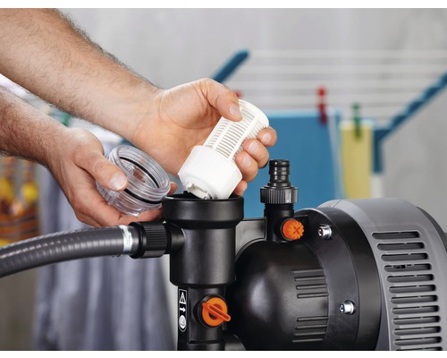 Person setzt Filter in eine Gartenpumpe ein.