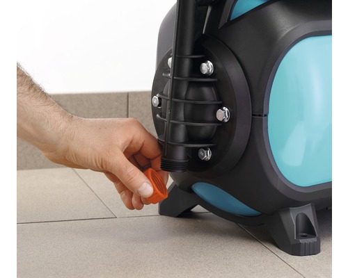 Detailaufnahme einer Gartenpumpe mit Hand, die einen Verschluss anbringt.