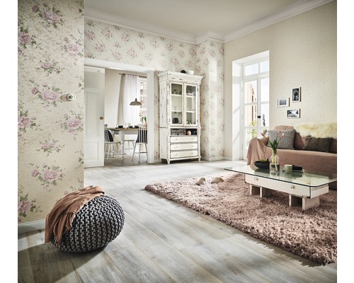 Wohnzimmer mit floraler Tapete, Sofa, Teppich und Holzfußboden für ein helles Ambiente.