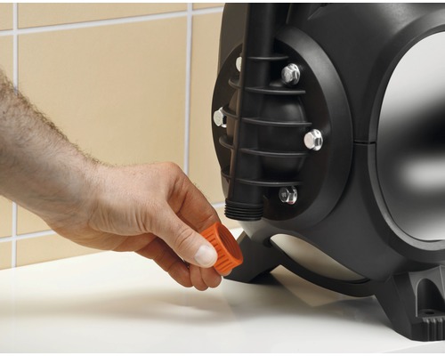 Eine Person befestigt eine Verschlusskappe an einer Gartenpumpe.