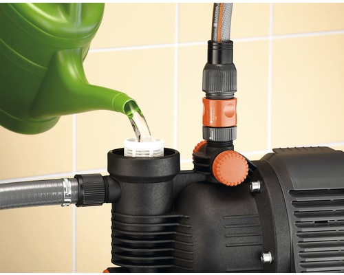 Befüllung einer Gartenpumpe mit einer Gießkanne.