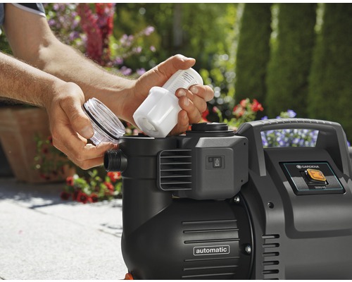 Eine Person setzt einen Filter in eine Gardena Gartenpumpe ein.