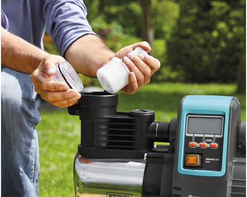 Ein Mann setzt einen Filter in eine Hauswasseranlage ein.