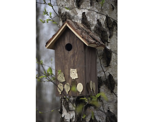 Vogelhaus aus Holz mit Eulen- und Blätterdekoration an einem Baum