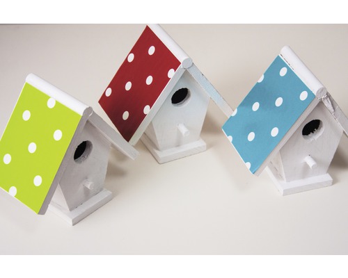 Drei weiße Vogelhäuser mit gepunkteten Dächern
