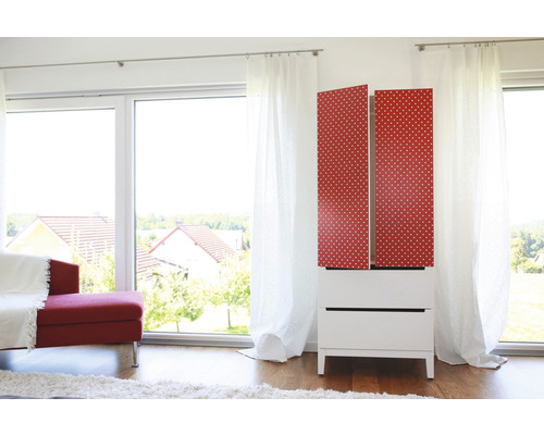 Moderner weißer Schrank mit roten Türen und weißem Punktmuster in einem hellen Raum