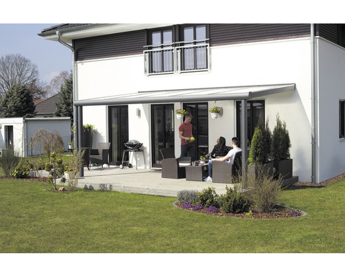 Terrasse mit Terrassenüberdachung an einem Wohnhaus mit Gartenmöbeln und Grill